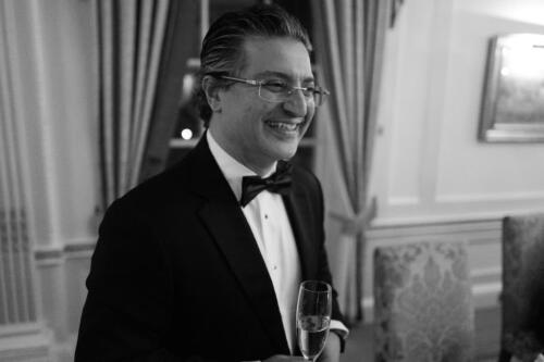 Kayvan smiling close up with champagne BW