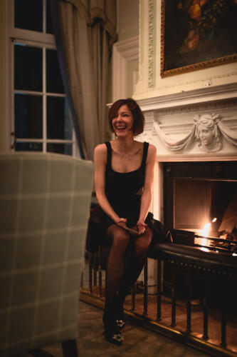Stephanie Hirschmiller smiling next to fireplace